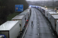 Lorries are parked on the M20 near Folkestone, Kent, England as part of Operation Stack after the Port of Dover was closed and access to the Eurotunnel terminal suspended following the French government's announcement, Monday, Dec. 21, 2020. France banned all travel from the UK for 48 hours from midnight Sunday, including trucks carrying freight through the tunnel under the English Channel or from the port of Dover on England's south coast. (Steve Parsons/PA via AP)