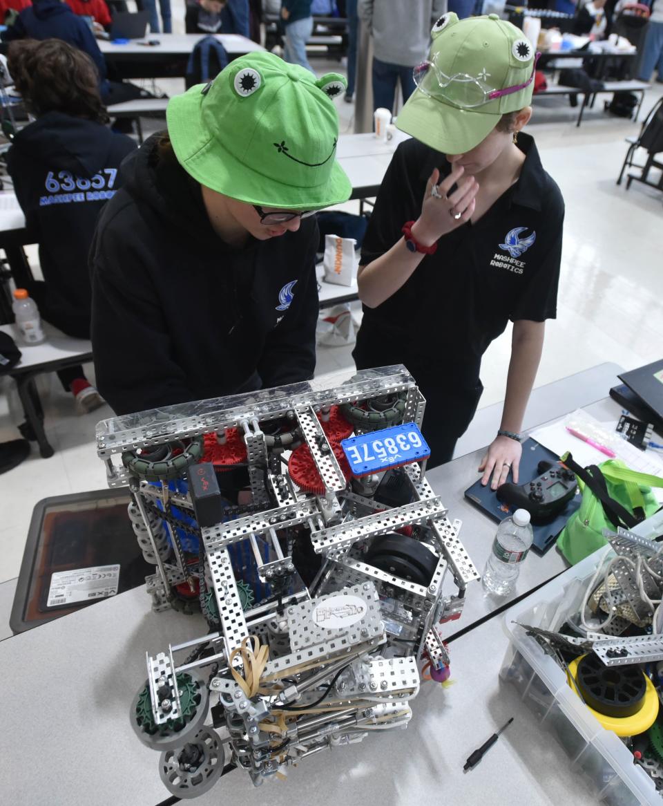 Team Aviator members Katrina Mayen, left, and Jamie Hughes swap out a battery on their robot on Saturday at Mashpee Middle-High School, before heading to the staging area at a regional robotics competition. Mayen and Hughes, both seniors, head to a world robotics championship on April 25.