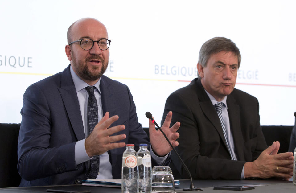 FILE - In this June 21, 2017 file photo, Belgian Prime Minister Charles Michel, left, and Belgium's Interior Minister and the N-VA's top official in the government Jan Jambon address the media during a press conference at the prime ministers office in Brussels. Belgium's government crisis eased somewhat on Wednesday after the biggest coalition partner said it would remain in the government despite its opposition to an U.N. migration pact that the others back. (AP Photo/Virginia Mayo)