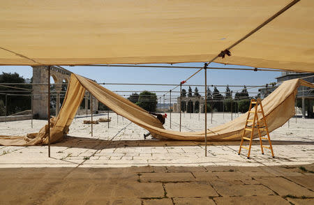 An employee of the Jordanian Waqf, or Islamic trust, that oversees the area, constructs a shade during preparations for the Muslim holy month of Ramadan on the compound known to Muslims as al-Haram al-Sharif and to Jews as Temple Mount, in Jerusalem's Old City, May 6, 2017. REUTERS/Ammar Awad