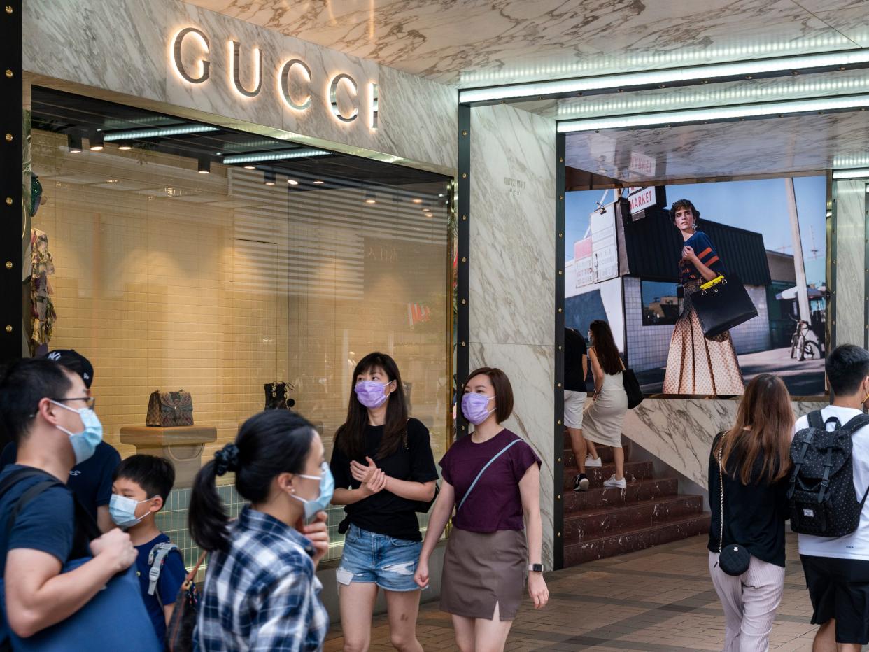 Shoppers with face masks walking past a Gucci shop in Hong Kong..