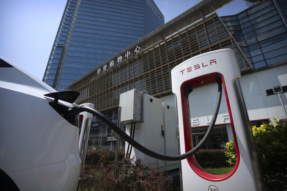 A vehicle charges at an electric vehicle charging station outside of a Tesla dealership in Beijing, Saturday, June 24, 2023. Threatened by possible shortages of lithium for electric car batteries, automakers are racing to lock in supplies of the once-obscure "white gold" in a politically and environmentally fraught competition from China to Nevada to Chile. (AP Photo/Mark Schiefelbein)