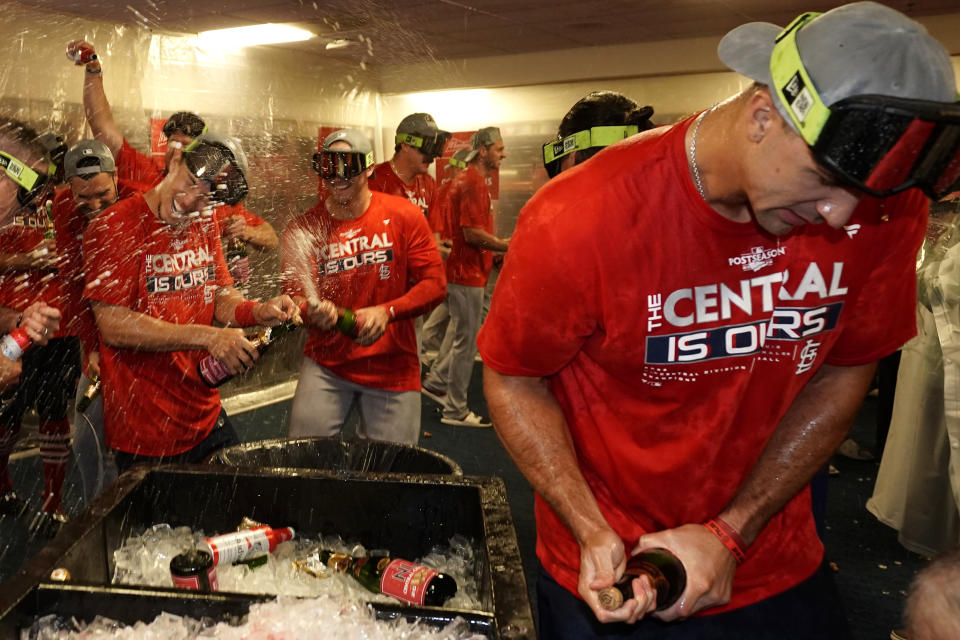 St. Louis Cardinals' Jack Flaherty, right, celebrates with teammates including Andrew Knizner, center, and Tommy Edman, left, after defeating the Milwaukee Brewers in a baseball game to win the National League Central title Tuesday, Sept. 27, 2022, in Milwaukee. (AP Photo/Morry Gash)