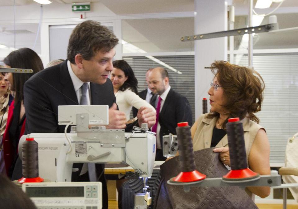 French Minister for Industrial Recovery Arnaud Montebourg talks to workers during a visit of "Particular operation days" in LVMH, the world's largest luxury company at the factory of Vuitton, in Asnieres, France, north of Paris Saturday June 15, 2013.(AP Photo/Jacques Brinon)