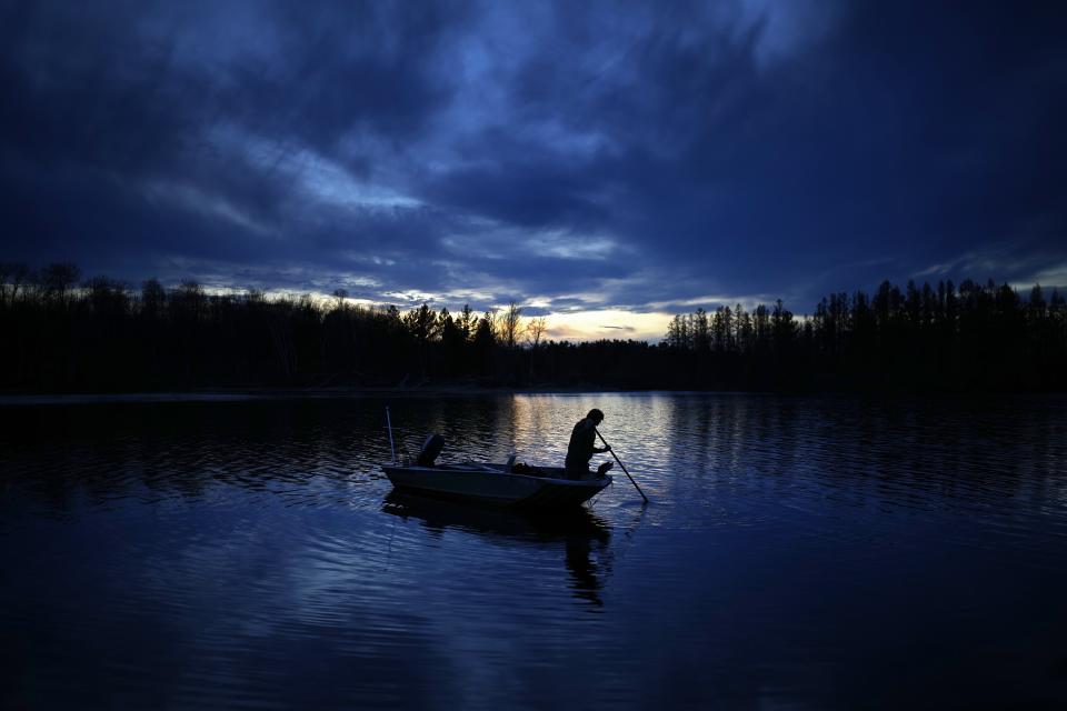 Gabe Bisonette uses a pole to move his boat toward shore while getting ready for a night of spearfishing on the Chippewa Flowage Monday, April 15, 2024, near Hayward, Wis. (AP Photo/John Locher)