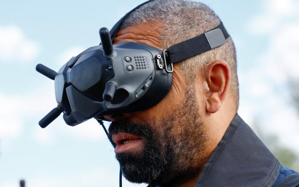 James Cleverly operates an unmanned demining vehicle as he visits members of the Halo Trust non-commercial charity organisation for demining - VALENTYN OGIRENKO/REUTERS