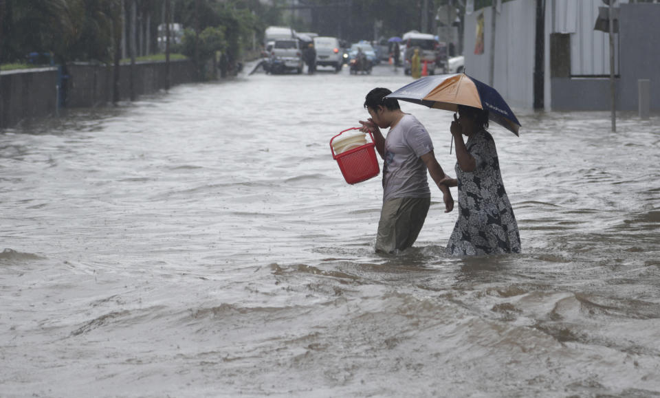 Indonesian people wade through floodwaters in Jakarta, Indonesia, Monday, Feb. 9, 2015. Seasonal rains and high tides in recent days have caused widespread flooding across much of Indonesia. (AP Photo/Achmad Ibrahim)