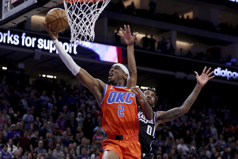 Oklahoma City Thunder guard Shai Gilgeous-Alexander (2) shoots against Sacramento Kings guard Malik Monk (0) during the second half of an NBA basketball game in Sacramento, Calif, Thursday, Dec. 14, 2023. (AP Photo/Jed Jacobsohn)