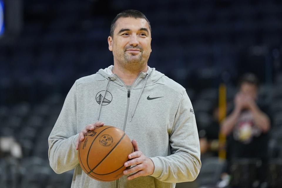 Golden State Warriors assistant coach Dejan Milojevic holds a ball before a preseason game between the Golden State Warriors.