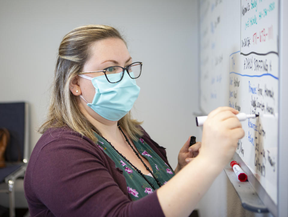 Heather Griggs, a registered nurse and operations chief of the Umatilla County Public Health Department contact tracing center in Pendleton, Ore., updates a list of job assignments on Tuesday, July 14, 2020. In tiny Umatilla County in northeastern Oregon, contact tracers work out of a converted jail to try to stem the spread of COVID-19 as new cases surge in the rural West and elsewhere. (AP Photo/Ben Lonergan)