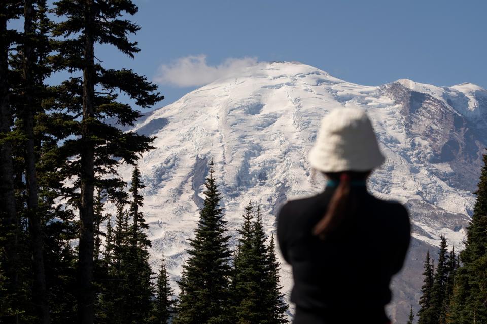 A visitor takes a photo of snow-capped Mount Rainier from Sunrise Point at Mount Rainier National Park on Sept. 21, 2023.