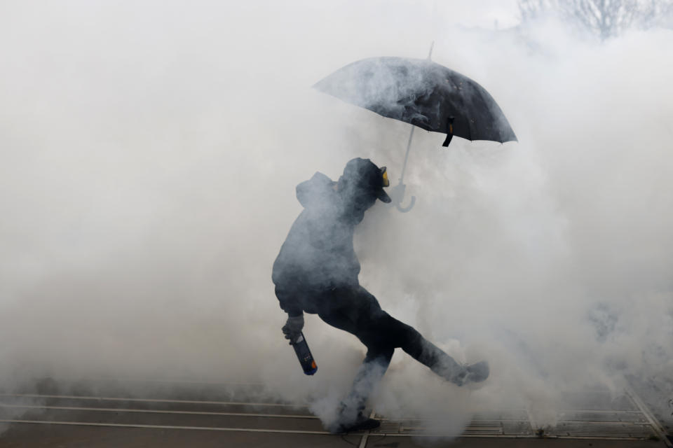 Protesters kicks a teargas canister as he clashes with police during a demonstration in Nantes, western France, Wednesday, March 15, 2023. Opponents of French President Emmanuel Macron's pension plan are staging a new round of strikes and protests as a joint committee of senators and lower-house lawmakers examines the contested bill. (AP Photo/Jeremias Gonzalez)