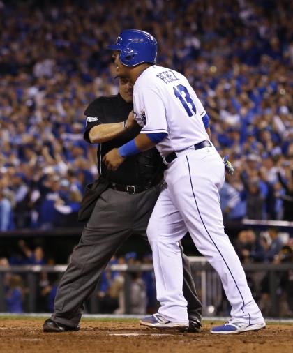 Home plate umpire Eric Cooper holds back Royals catcher Salvador Perez. (AP)