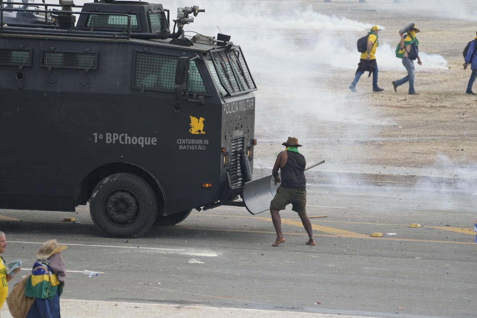 Protesters, supporters of Brazil's former President Jair Bolsonaro, attack a police vehicle after they stormed the Planalto Palace in Brasilia, Brazil, Sunday, Jan. 8, 2023. Planalto is the official workplace of the president of Brazil. (AP Photo/Eraldo Peres)