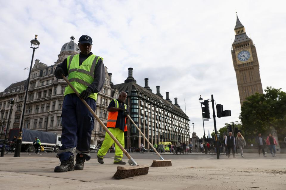 Cleaners sweep the streets in Parliament Square after Queen Elizabeth's funeral