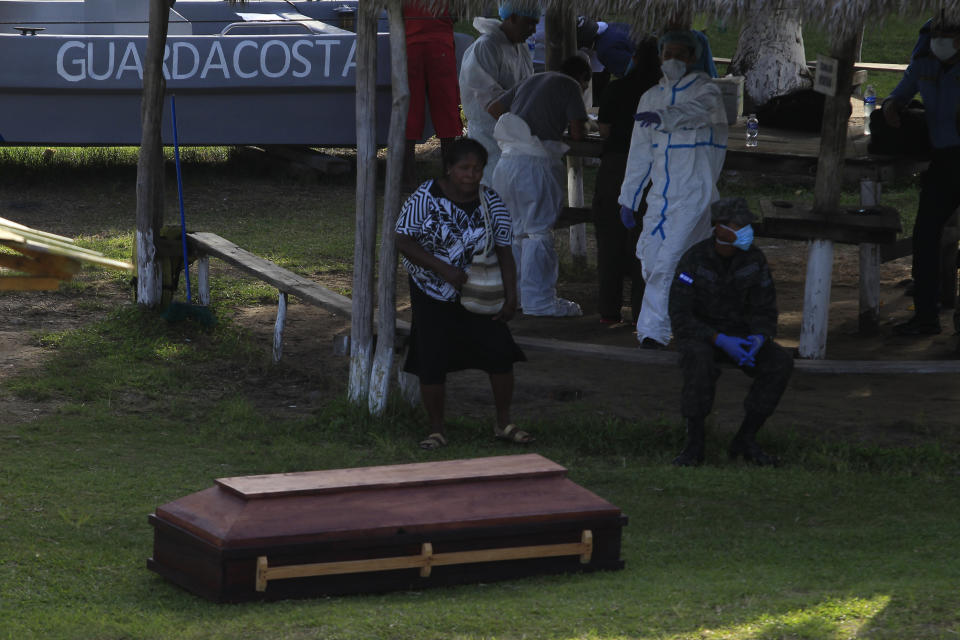 A woman stands next to the coffin of her relative, who died after a fishing boat capsized off the Atlantic coast of Honduras, at the Catarasca Naval Base, in Puerto Lempira, Honduras, Thursday, July 4, 2019. The fishing vessel sank during bad weather Wednesday near Cayo Gorda in the Caribbean off Honduras' northern coast. (Jorge Cabrera/Pool via AP)