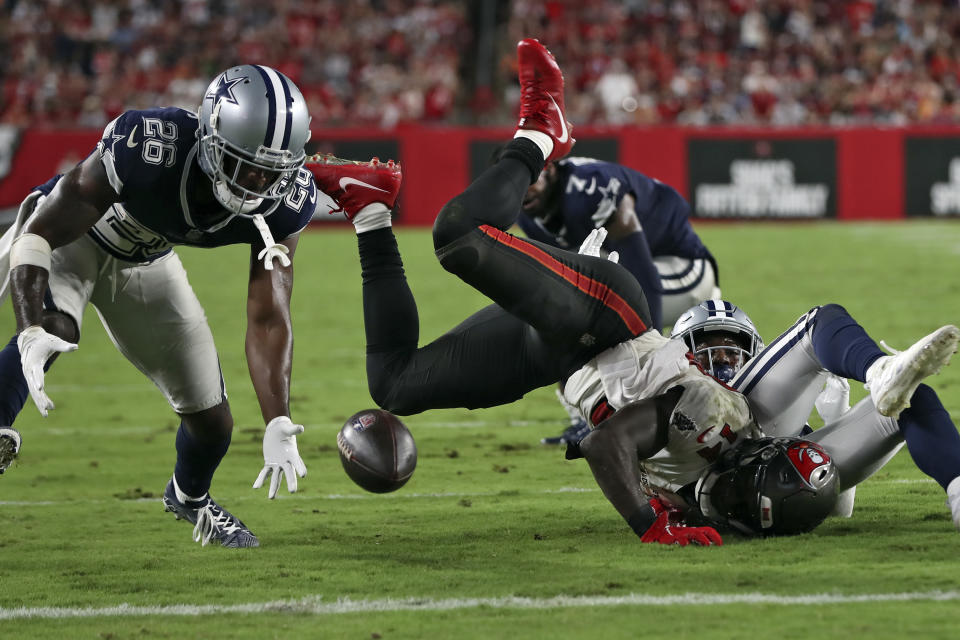 Dallas Cowboys cornerback Jourdan Lewis (26) picks up a fumble by Tampa Bay Buccaneers wide receiver Chris Godwin (14) during the second half of an NFL football game Thursday, Sept. 9, 2021, in Tampa, Fla. (AP Photo/Mark LoMoglio)