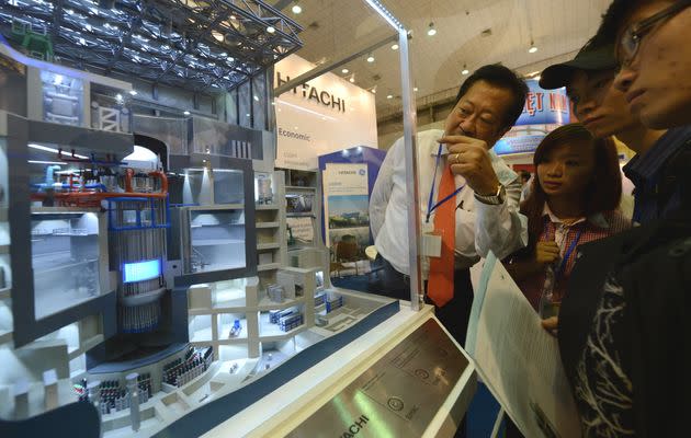 Students look at a model of a nuclear power plant jointly designed by Hitachi and General Electric on display at an international nuclear power exhibition being held in Hanoi, Vietnam, in October 2012. (Photo: HOANG DINH NAM via Getty Images)