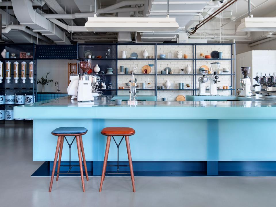 The space is not afraid to mix materials as steel joinery sets the backdrop for resin coffee counters and exposed, painted brickwork.