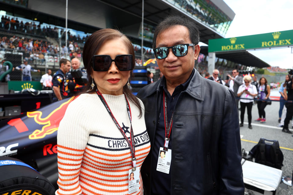 Chalerm Yoovidhya and Daranee Yoovidhya pose for a photo with the car of Max Verstappen of the Netherlands and Oracle Red Bull Racing on the grid during the F1 Grand Prix of Austria at Red Bull Ring on July 10, 2022 in Spielberg, Austria.