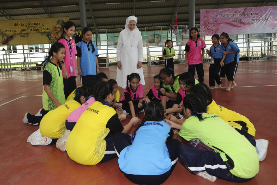 In this Aug. 27, 2019, photo, ST. Mary's School Vice Principal Sister Ana Rosa Sivori, rear center, watches students play during a lunch break at the girls' school in Udon Thani, about 570 kilometers (355 miles) northeast of Bangkok, Thailand. Sister Ana Rosa Sivori, originally from Buenos Aires in Argentina, shares a great-grandfather with Jorge Mario Bergoglio, who, six years ago, became Pope Francis. So, she and the pontiff are second cousins. (AP Photo/Sakchai Lalit)
