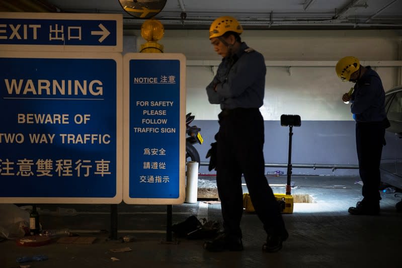 Fire services department officers are seen next to a sewer which is believed to be an escape route for anti-government protesters after being barricaded by police officers in Hong Kong