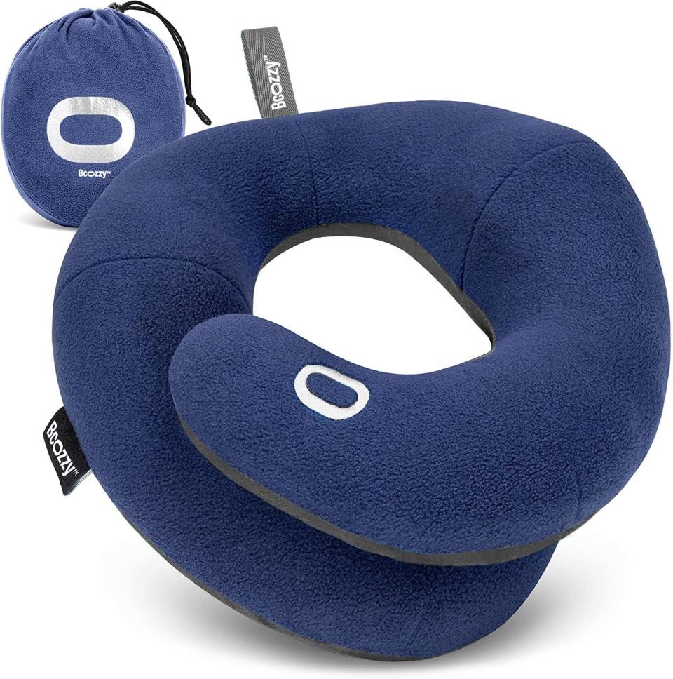 A dark blue BCOZZY travel pillow against a white background