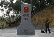 A Vietnamese border guard stands next to a border marker between China's Guangxi and Vietnam's Lang Son provinces in this January 13, 2009 file photo. REUTERS/Kham/Files