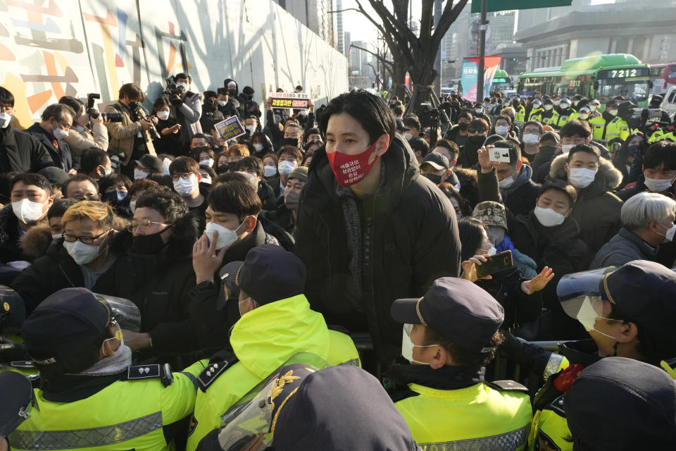 Small business owners confront police officers during a rally against the government's social distancing rules near the Government Complex in Seoul, South Korea, Wednesday, Dec. 22, 2021. Hundreds of small business owners rallied on Wednesday, calling for the withdrawal of curfews and other strict COVID-19 restrictions on restaurants, cafes, gyms and other facilities. (AP Photo/Ahn Young-joon)