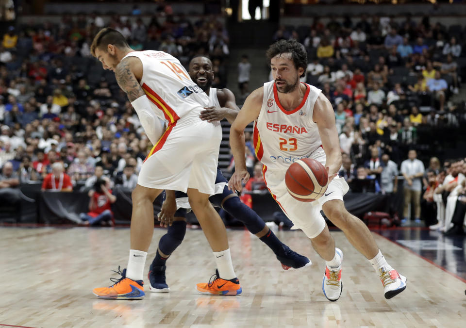 Spain's Sergio Llull, right, dribbles around a screen set by Willy Hernangomez, left, and on United States' Kemba Walker during the first half of an exhibition basketball game Friday, Aug. 16, 2019, in Anaheim, Calif. (AP Photo/Marcio Jose Sanchez)