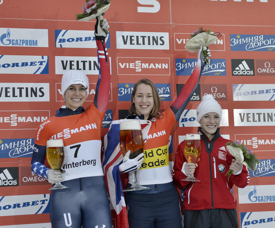 Elizabeth Yarnold of Great Britain, center, celebrates on the podium after winning the women's Skeleton World Cup in Winterberg, Germany, on Saturday, Jan. 4, 2014. Noelle Pikus-Pace of the USA finished second, left, Sarah Reid from Canada finished third, right.(AP Photo/Martin Meissner)