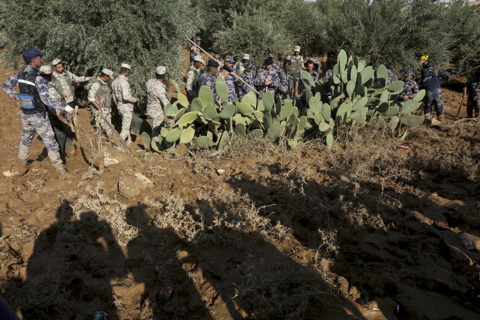 Jordanian rescue teams search Saturday, Nov. 10, 2018 for missing people in the Madaba area, south of the capital of Amman, after flash floods unleashed by heavy rain a day earlier killed at least 12 people. (AP Photo/Raad Adayleh)