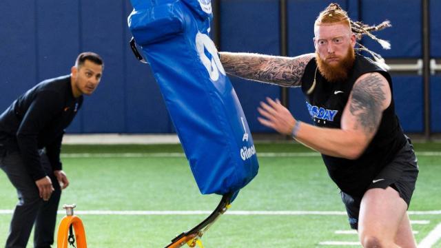 Former Boise State defensive lineman Scott Matlock punishes a blocking sled obstacle while running a drill at Pro Day, where NFL scouts measured, weighed and drilled Broncos hoping for a shot at professional football, Monday, March 27, 2023.