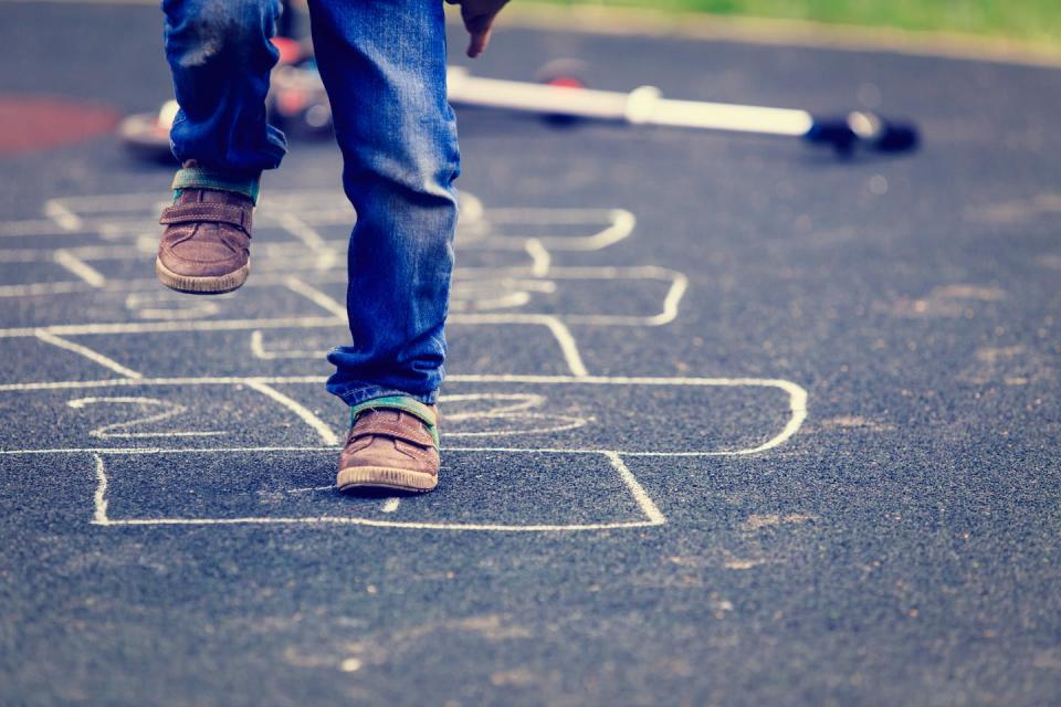 A child jumping on hopscotch.