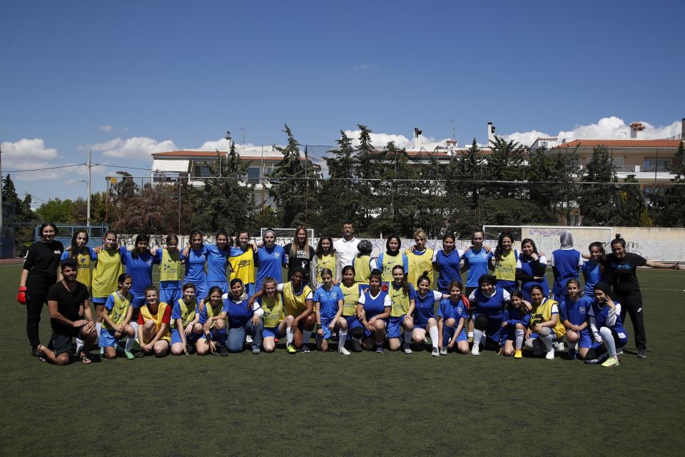 In this Thursday, May 2, 2019 photo, members Hestia FC Women's Refugee Soccer and AO Vrilission players pose for a photograph before a friendly game in Athens. Many of the players at Hestia FC weren't allowed to play or even watch soccer matches in their home countries. Hestia FC was set up by the Olympic Truce Centre, a non-government organization created in 2000 by the International Olympic Committee and Greek Foreign Ministry. (AP Photo/Thanassis Stavrakis)