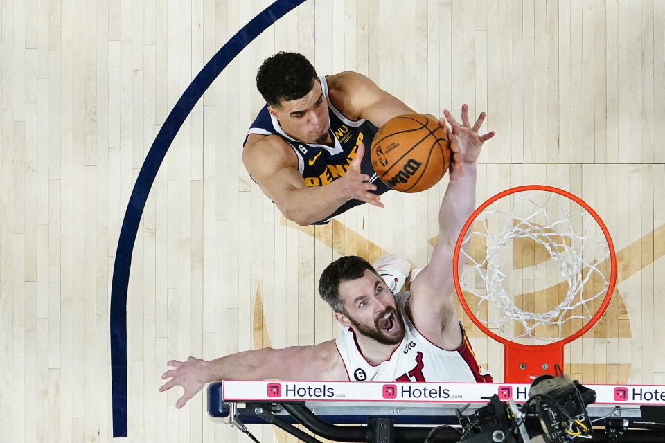 Miami Heat forward Kevin Love, bottom, reaches for a loose ball against Denver Nuggets forward Michael Porter Jr. during the second half of Game 2 of basketball's NBA Finals, Sunday, June 4, 2023, in Denver. (Kyle Terada/Pool Photo via AP)