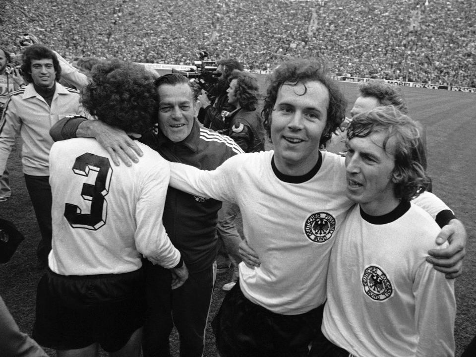 ARCHIVO - El capitán de Alemania Occidental Franz Beckenbauer (segundo a la derecha) abraza a su compañero Juergen Grabowski en el Estadio Olímpico de Múnich al celebrar la victoria 2-1 ante Holanda en la final de la Copa del Mundo, el 7 de julio de 1974. (AP Foto, archivo)