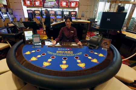 A dealer mans a stud poker table at the new Broadway Macau casino, adjacent to Galaxy Macau resort, in Macau, China May 26, 2015, one day before its opening. REUTERS/Bobby Yip