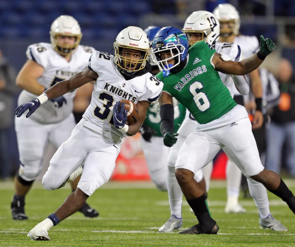 Hoban running back Lamar Sperling, left, rushes for a first down ahead of Winton Woods linebacker Seven Blue during the first half of the OHSAA Division II State Championship football game at Tom Benson Hall of Fame Stadium, Thursday, Dec. 2, 2021, in Canton, Ohio.