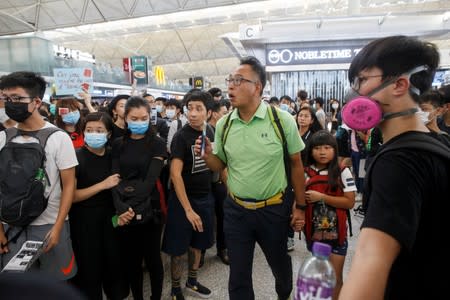 Passengers arrive at the departure gate as anti-extradition bill protesters rally at of Hong Kong airport in Hong Kong