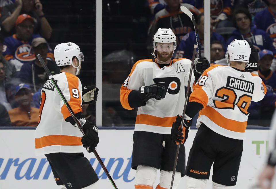 Philadelphia Flyers defenseman Ivan Provorov (9) and Flyers defenseman Robert Hagg (8) celebrate with Flyers center Sean Couturier (14) who scored the Flyers fourth goal during the second period of an NHL hockey game, Sunday, March 3, 2019, in Uniondale, N.Y. The Flyers defeated the Islanders 4-1. (AP Photo/Kathy Willens)