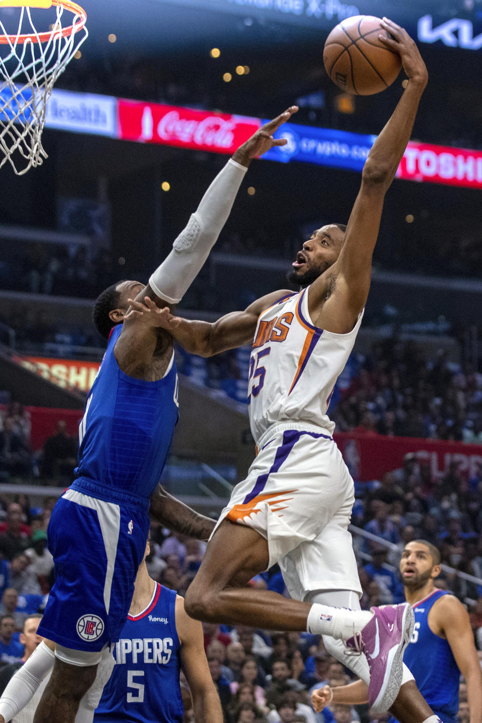 Phoenix Suns forward Mikal Bridges, right, goes for a dunk against Los Angeles Clippers guard John Wall during the first half of an NBA basketball game, Sunday, Oct. 23, 2022, in Los Angeles. (AP Photo/Alex Gallardo)