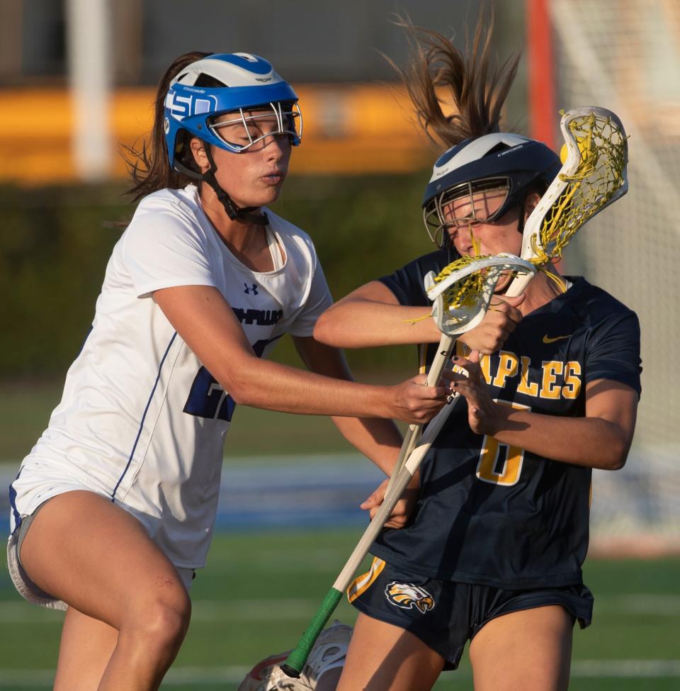 Stella Lynch of the Community School of Naples Lacrosse team and Nyah Blume of Naples fight for the ball during a district game at CSN on Thursday, April 18, 2024.