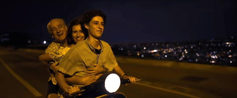 Toni Servillo, Teresa Saponangelo, and Filippo Scotti ride on a moped