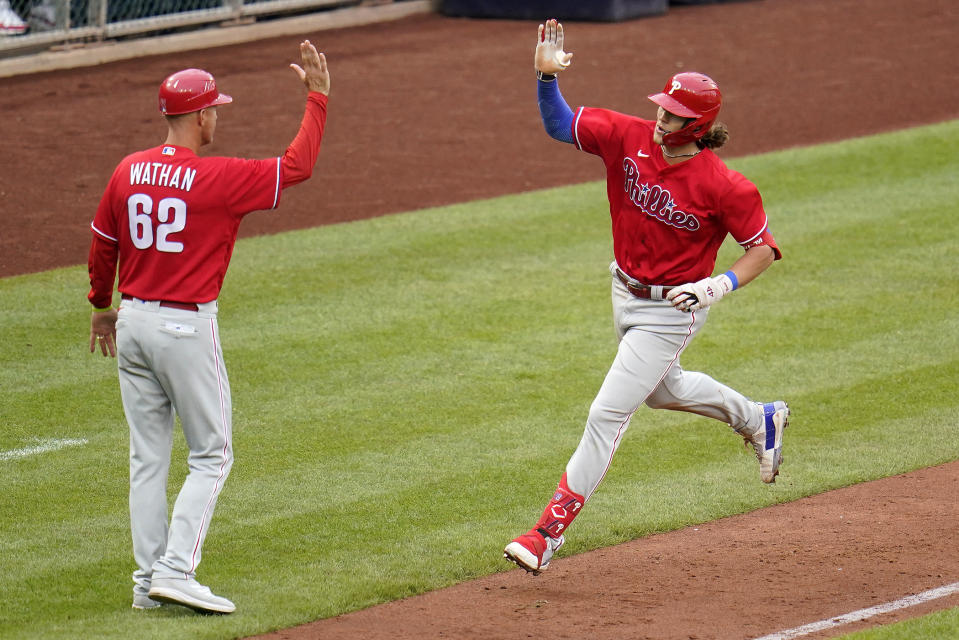 Philadelphia Phillies' Alec Bohm, right, rounds third to greetings from third base coach Dusty Wathan after hitting a solo home run off Pittsburgh Pirates relief pitcher Dillon Peters during the sixth inning of a baseball game in Pittsburgh, Sunday, July 31, 2022. (AP Photo/Gene J. Puskar)