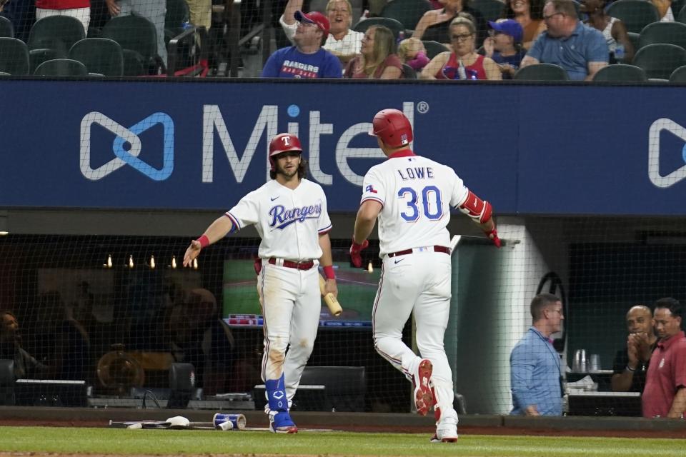 Texas Rangers' Jonah Heim, left, and Nathaniel Lowe (30) celebrate after Lowe hit a solo home run in the fifth inning of a baseball game against the Philadelphia Phillies, Tuesday, June 21, 2022, in Arlington, Texas. (AP Photo/Tony Gutierrez)