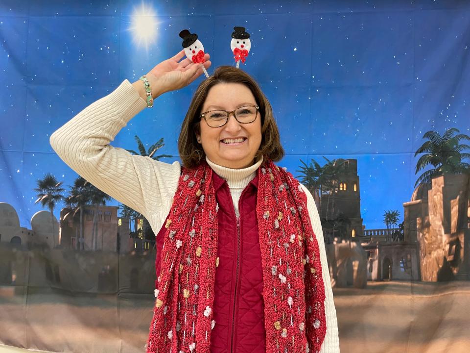 Ever the good sport, Pastor Teresa Atkins McClure pauses for a photo at one of the many biblical backdrops available at the annual Community Christmas Party at Beaver Ridge United Methodist Church on Dec. 17, 2023.