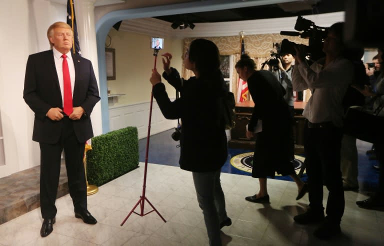 Members of the media attend the unveiling of the new wax figurine of President-elect Donald Trump (L) at Madame TussaudÕs wax museum in Washington, DC