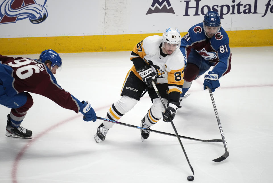 Pittsburgh Penguins center Sidney Crosby, middle, drives between Colorado Avalanche right wing Mikko Rantanen, left, and center Denis Malgin in the third period of an NHL hockey game Wednesday, March 22, 2023, in Denver. (AP Photo/David Zalubowski)