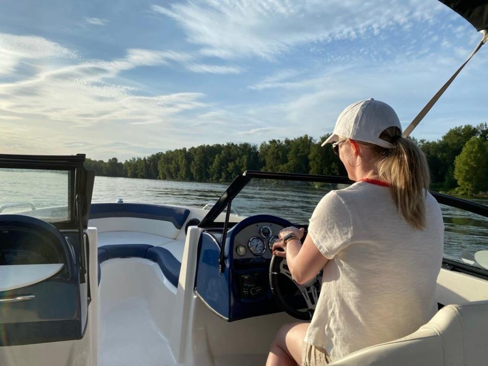 jodi driving a speed boat on a river in the pacific northwest